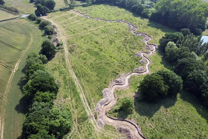 Après les travaux de renaturation, le tronçon du Guinguenoual a retrouvé la sinuosité naturelle de son lit mineur et s’insère dans un écrin vert de zones en herbe et de haies bocagères. Crédit photo : Dinan Agglomération